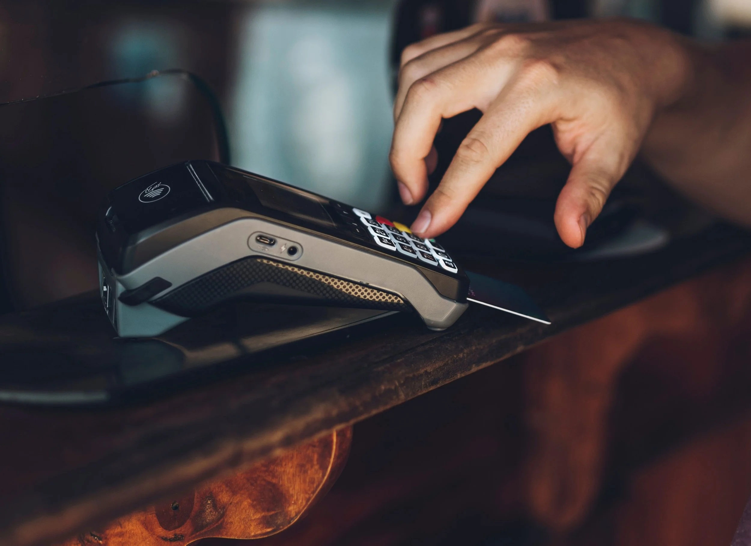 Hand tapping and swiping payment card on contactless terminal